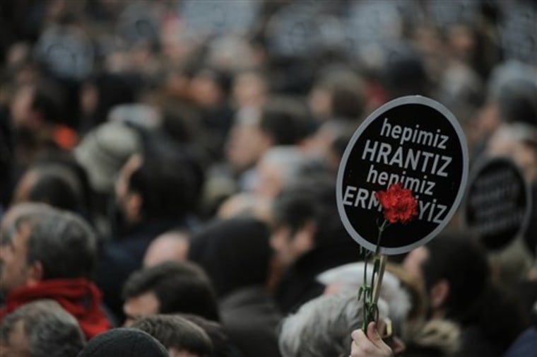 A person holds a banner that reads \"We are all Hrant, we are all Armenian\" as some tens of thousands of protesters march to mark the fifth anniversary of Turkish-Armenian journalist Hrant Dink's murder in Istanbul, Turkey, Thursday, Jan. 19, 2012 as outrage continues to grow over a trial that failed to shed light on alleged official negligence or even collusion. Human rights activists placed red carnations on the spot in Istanbul where Dink was gunned down in broad daylight outside of his minority Agos newspaper office by a nationalist teenage gunman. The case highlights Turkey's uneasy relationship with its ethnic and religious minorities, including at least 60,000 Armenian Christians.(AP Photo)